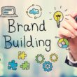 Businessman drawing Brand Building concept on blurred abstract background
