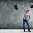 Man holding up a barbell weight standing in front of a chalkboard with different graphs and equations on it